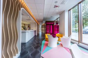 a lobby with colorful chairs and a bar at Prize by Radisson, Antwerp City in Antwerp