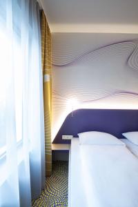 a bedroom with a bed and a window at Prize by Radisson, Antwerp City in Antwerp