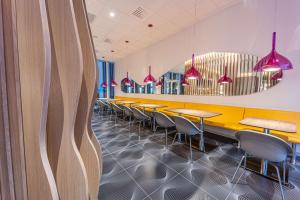 a dining room with a row of tables and chairs at Prize by Radisson, Antwerp City in Antwerp