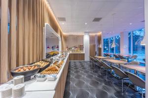 a restaurant with a buffet line with tables and chairs at Prize by Radisson, Antwerp City in Antwerp