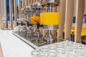 a tray of glasses on a table with a yellow candle at Prize by Radisson, Antwerp City in Antwerp