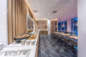 a restaurant with tables and chairs and a buffet at Prize by Radisson, Antwerp City in Antwerp