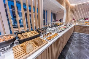 a buffet line with bread and other foods on display at Prize by Radisson, Antwerp City in Antwerp
