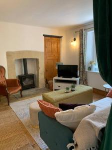 a living room with a couch and a fireplace at 2 bed cottage nr Glastonbury festival, Frome, Bath in Shepton Mallet