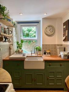 a kitchen with a sink and a clock on the wall at 2 bed cottage nr Glastonbury festival, Frome, Bath in Shepton Mallet +13 photos