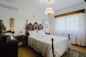 アルコス・デ・ヴァルデヴェスにあるQuinta do Passal - Gondorizの大きなベッドとシャンデリアのある寝室