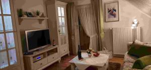 un salon avec une télévision et une table dans l'établissement Ferienwohnung Neumann, à Wesselburen