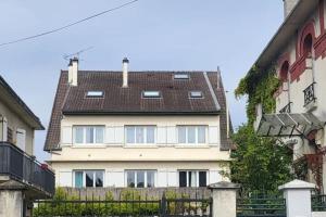 una grande casa bianca con il tetto nero di GRAND DUPLEX proche de PARIS a Saint-Maur-des-Fossés