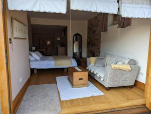 a living room with a couch and a bed at Old Chapel of Ermington - Converted Vestry in Ivybridge