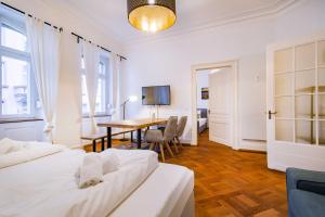 ein Schlafzimmer mit 2 Betten und ein Esszimmer mit einem Tisch in der Unterkunft StayInn "Heart of the City" Suite in Freiburg im Breisgau