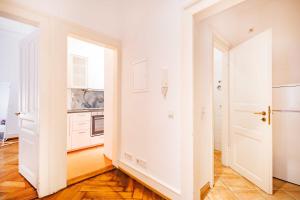 eine Küche mit weißen Wänden und Holzboden in der Unterkunft StayInn "Heart of the City" Suite in Freiburg im Breisgau