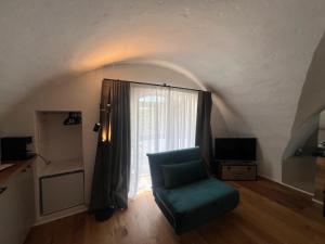 a living room with a chair and a window at Dimora NONNA CATERINA in Monopoli