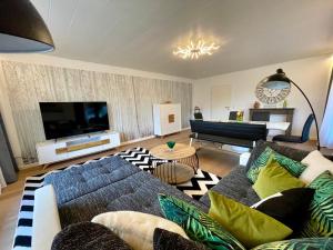 a living room with a couch and a flat screen tv at Ferienhaus Hanni und Fanni in Taching am See