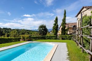 a swimming pool in front of a house with a fence at Agriturismo San Martino in Clavesana