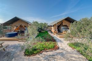 ein paar Zelte, Bäume und eine Terrasse in der Unterkunft Adriatic Heritage Glamping No2 with Jacuzzi in Donje Selo na Šolti