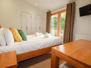 Un dormitorio con una cama y una mesa y una ventana. en 6 Streamside, en Looe