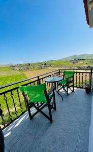 two chairs and a table on a balcony with a view at Fergani Apartments in Moúdhros