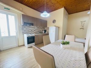 a kitchen with a table with chairs and a refrigerator at Fergani Apartments in Moúdhros