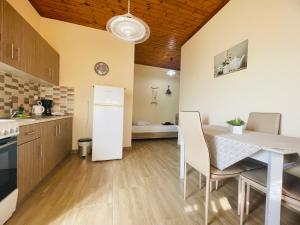 a kitchen with a table and chairs and a refrigerator at Fergani Apartments in Moúdhros