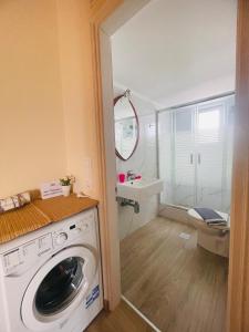 a washing machine in a bathroom with a sink at Fergani Apartments in Moúdhros