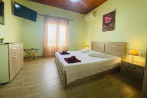 a bedroom with a large white bed and a window at Fergani Apartments in Moúdhros