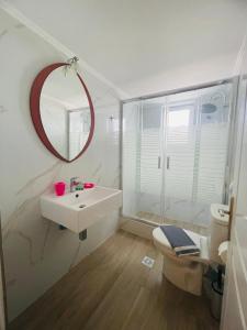 a bathroom with a sink and a toilet and a mirror at Fergani Apartments in Moúdhros