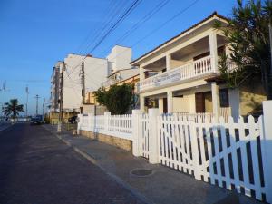 uma cerca branca em frente a uma casa em Pousada Casa dos Sonhos em Rio das Ostras