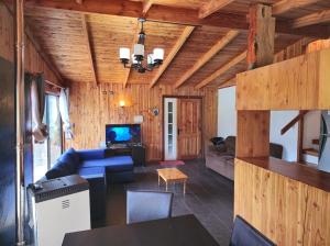 a living room with a blue couch and a tv at Cabaña 8 a 9 personas ideal 2 matrimonios y niños in Coñaripe