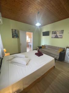 a large white bed in a room with a couch at Fergani Apartments in Moúdhros