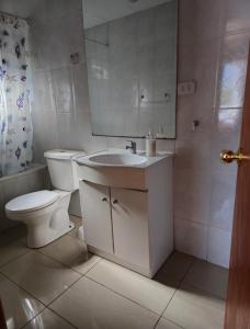 Cabaña 8 a 9 personas ideal 2 matrimonios y niños في كونياريبي: حمام مع مرحاض ومغسلة ومرآة +29 صورة