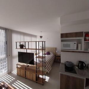 una sala de estar con una habitación con cama y TV en Muy cómodo Excelente ubicación, en Buenos Aires