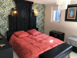 una camera con letto rosso e testiera nera di Villaloha Deluxe Bray-dunes Beach a Bray-Dunes