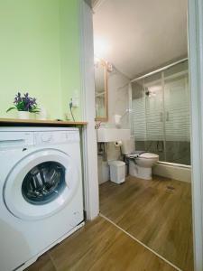 a washing machine in a bathroom with a toilet at Fergani Apartments in Moúdhros