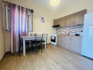 a kitchen and dining room with a table and chairs at Fergani Apartments in Moúdhros