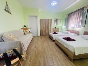 a room with two beds and a couch at Fergani Apartments in Moúdhros