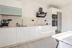 a white kitchen with white cabinets and appliances at A Neida Casa con terraza con vistas al mar in Cee