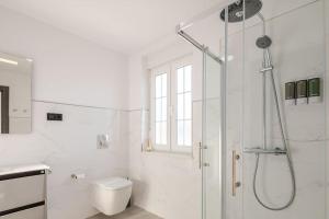 a white bathroom with a shower and a toilet at A Neida Casa con terraza con vistas al mar in Cee +27 photos