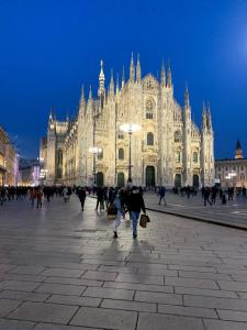 ミラノにあるGS Brera Homeの大きな建物の前を歩く人々