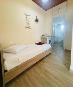 a bedroom with a bed and a wooden floor at Fergani Apartments in Moúdhros