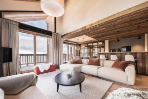 un soggiorno con un divano e un tavolo di Antarès MIRA 202 - Pretigious rooftop apartment ski inski out a Méribel
