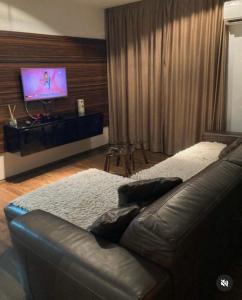 un soggiorno con divano e TV a schermo piatto di Apartman 11 a Leskovac