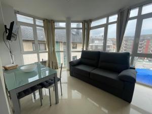 a living room with a couch and a glass table at Apartamento 4º planta centro Ribeira by Cristian&Tamara "alquileres" in Ribeira
