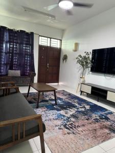 Una sala de estar con un televisor de pantalla plana y un sofá. en Homestay Kakak Adek with private pool sempadan Perak,Penang dan Kedah, en Bandar Baharu