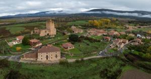 an aerial view of a village with a castle at La Laguna in Hinojosa de la Sierra