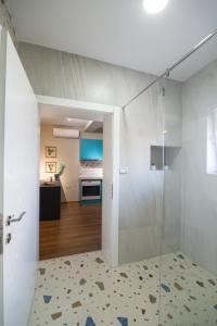 a bathroom with a shower with a glass door at Melnaz Apartament 2 in Korçë