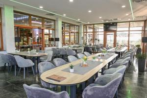 restauracja ze stołami, krzesłami i oknami w obiekcie Hotel Kralj w mieście Donji Kraljevec