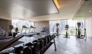 une salle de sport avec des rangées d'appareils d'exercice dans un bâtiment dans l'établissement Luxury condo right next to BTS Thonglor!, à Bangkok