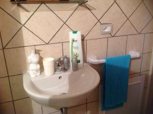 un lavandino in bagno con asciugamano blu di Pisceneris Holiday Home a Uras