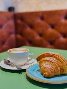 a cup of coffee and a croissant on a table at Palazzo CarpeDiem-Prato della Valle in Padova +54 photos