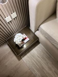 a coffee table with a bouquet of flowers on a couch at 101 - Comfy Space - 80TV smart - Self Check-in in Riyadh +2 photos